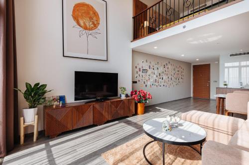a living room with a couch and a tv at Muse Hanoi PentStudio West Lake in Hanoi