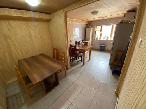 a kitchen and dining room with a table and chairs at Hostería Futaleufu in Futaleufú