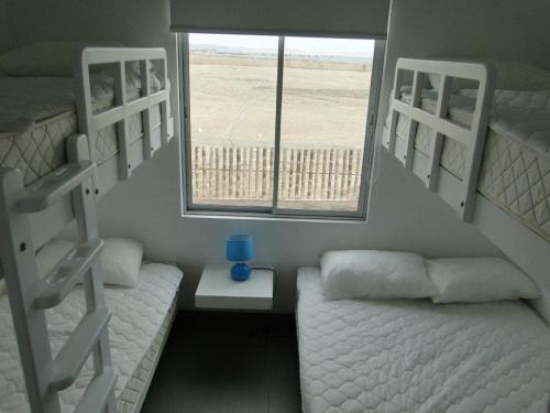 1 dormitorio con 2 literas y ventana en Nuevo Paracas, en Paracas