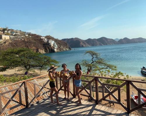 drie vrouwen die naast een hek op het strand staan bij HOSTAL MARIA ISABEL in Santa Marta