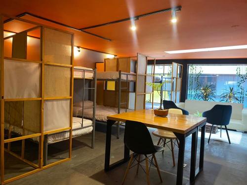 a room with a table and a room with bunk beds at Hostel Cowork en Chapinero in Bogotá