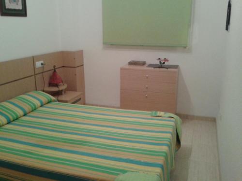 a bedroom with a bed and a greenboard on the wall at Costa Azahar Apartments Beach in Oropesa del Mar