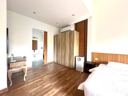 a bedroom with a bed and a desk and a bathroom at Villa 173 - Two bedroom private villa in Ban Pak Chong Noi