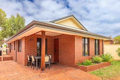a red brick house with a table and chairs at Kalbarri Tudor Holiday Park in Kalbarri
