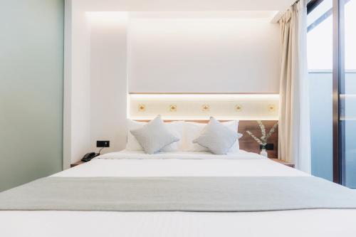a white bed with white pillows in a bedroom at Santa Grand Hotel East Coast a NuVe Group Collection in Singapore