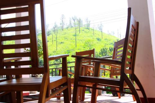 2 stoelen en een tafel op een balkon met uitzicht bij Sashen Hotel in Ella