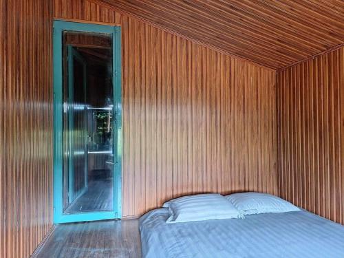 a bedroom with a bed in a wooden wall at Windy Home in Ấp Man Ling