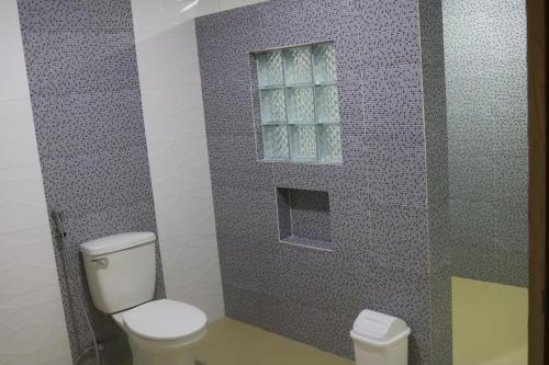 een badkamer met een toilet en een raam bij TAM-AN MOUNTAIN RESORT & HOTEL in Bayombong