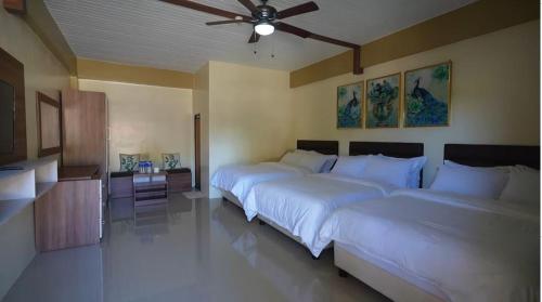 een slaapkamer met 2 bedden en een plafondventilator bij TAM-AN MOUNTAIN RESORT & HOTEL in Bayombong