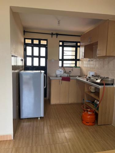 a kitchen with a refrigerator in the middle of it at Citypal Apartments in Meru