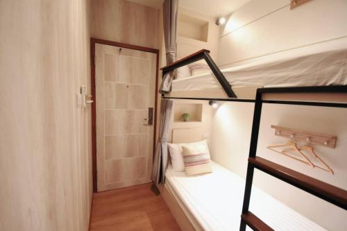 a small room with two bunk beds and a door at Silom Forest Exclusive Residence in Bangkok