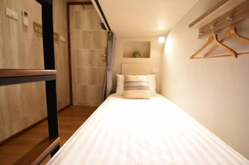 a small bedroom with a bed in a room at Silom Forest Exclusive Residence in Bangkok