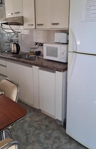 eine Küche mit einem weißen Kühlschrank und einer Spüle in der Unterkunft Güemes in Villa María