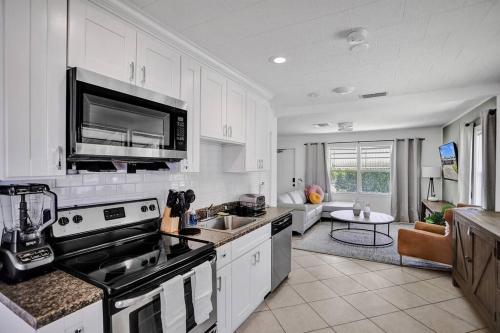a kitchen with white cabinets and a stove top oven at Palm Wave Says - 5 Star - Quiet Area - Stocked in West Palm Beach