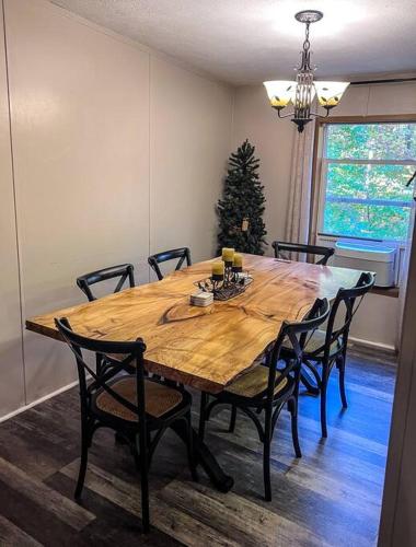 a dining room table with chairs and a christmas tree at Bern's Summit Solitude: Stream-Front Serenity in Confluence