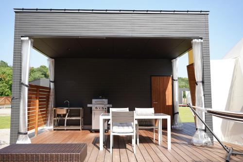 a black garage with a table and chairs on a deck at レドンド秋吉台 in Ōta