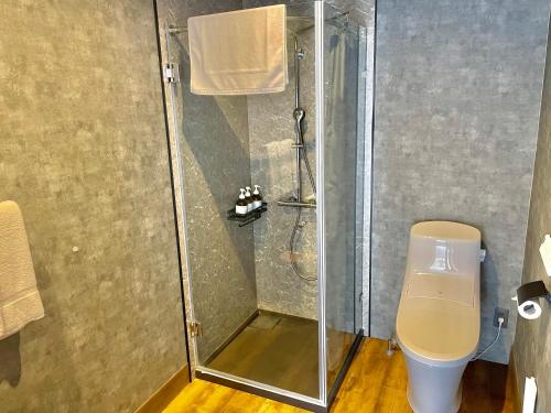 een douchecabine met een toilet in de badkamer bij レドンド秋吉台 