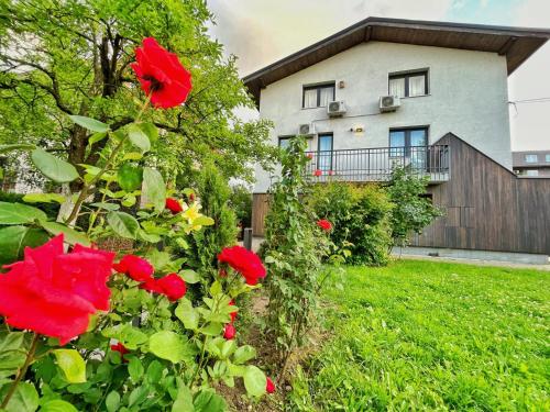 a house with red flowers in front of a yard at Villa BB in Sarajevo