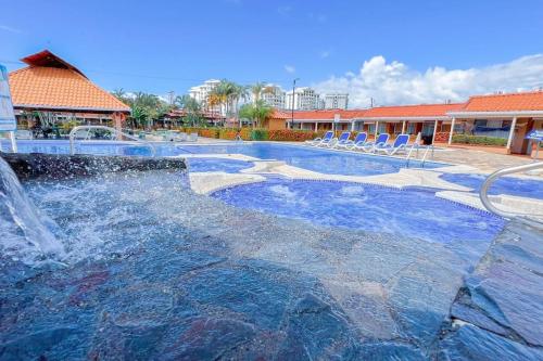 a swimming pool with a waterfall in a resort at Villa Paraíso banano 9, near to the beach & Pool in Jacó