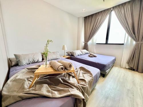 1 dormitorio con 2 camas y mesa. en LB Cozy Home 1-10Pax 3Room Tropicana 4QBeds BalconyTV en Petaling Jaya
