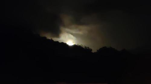a moon is hiding behind the trees in the sky at Hotel Pacuare Turrialba in Turrialba