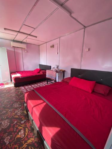 two beds in a room with pink walls at AsiaCamp - Cabin Sungai Sireh in Tanjung Karang