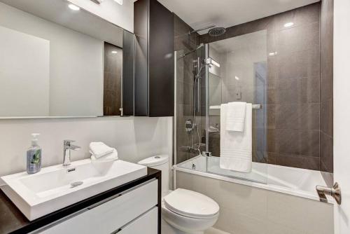 ein Bad mit einem Waschbecken, einem WC und einer Dusche in der Unterkunft Beautiful Downtown condo with Pool and Parking in Montreal