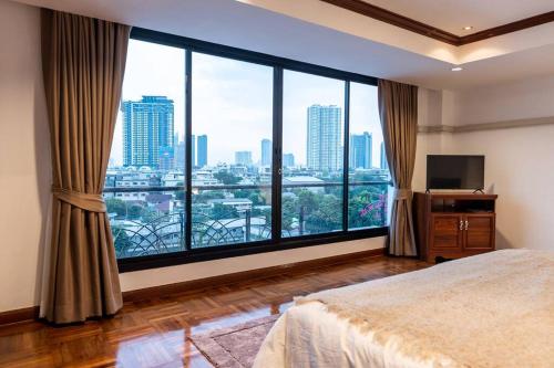 um quarto com uma grande janela com vista para a cidade em Rooftop Paradise & Koi Pond-6BR Hideaway@Icon Siam em Bangkok