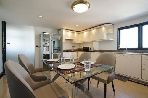 a kitchen with a dining room table and chairs at Rooftop Paradise & Koi Pond-6BR Hideaway@Icon Siam in Bangkok