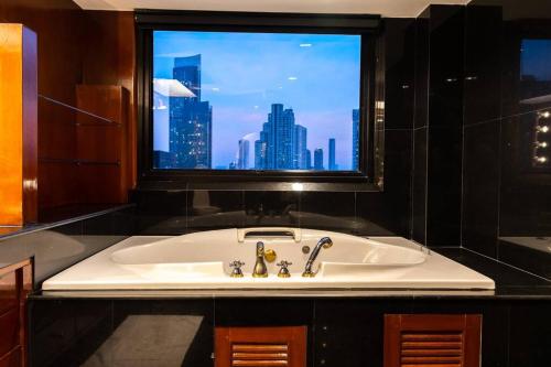 La salle de bains est pourvue d'une grande fenêtre au-dessus d'un lavabo. dans l'établissement Rooftop Paradise & Koi Pond-6BR Hideaway@Icon Siam, à Bangkok