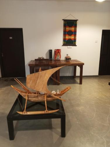 a wooden boat on a table in a room at Nade Villas Ahungalla in Ahungalla