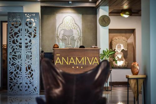 una sedia in una stanza con opere d'arte sul muro di Anamiva, Goa - AM Hotel Kollection ad Anjuna