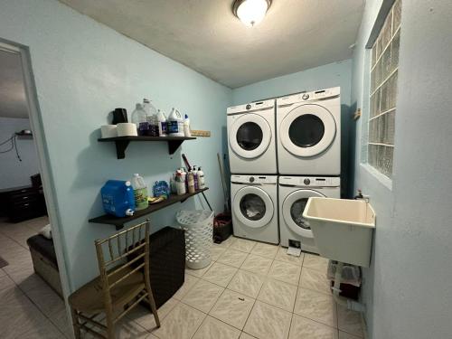 baño con 2 lavadoras y lavamanos en Countryside - Secluded NEAR LAGOON, RIVER and BEACH. First floor, en Vega Baja
