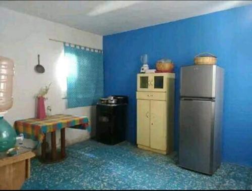 a blue kitchen with a refrigerator and a table at Posada Hortencia in Aguascalientes