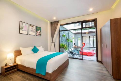 een slaapkamer met een bed en uitzicht op een patio bij 9BR villa, 200m from the sea in Da Nang