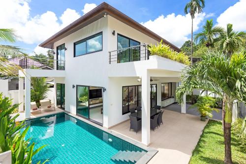 an exterior view of a house with a swimming pool at Villa White Pool in Kamala Beach