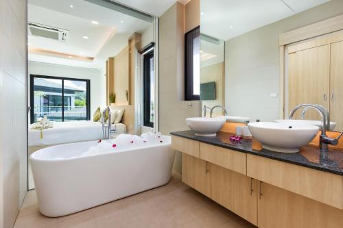 une salle de bain avec deux lavabos et une baignoire dans l'établissement Villa White Pool, à Kamala Beach