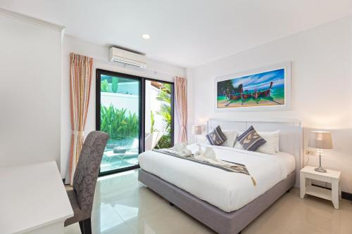 une chambre avec un lit, un bureau et une fenêtre dans l'établissement Villa White Pool, à Kamala Beach