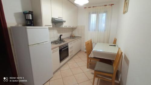 uma pequena cozinha com um frigorífico branco e uma mesa em Apartments Andrija - amazing view em Rtina
