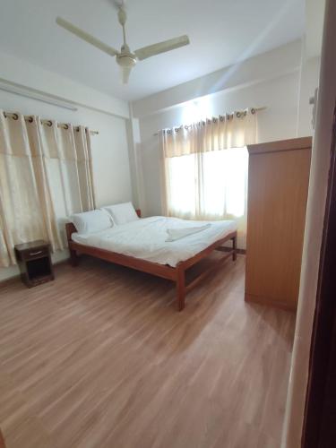 a bedroom with a large bed and a window at Fewa Apartment in Pokhara