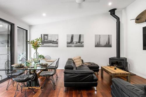 a living room with a table and a fireplace at Modern 3-Bedroom Byron Bay Escape With Sauna in Byron Bay