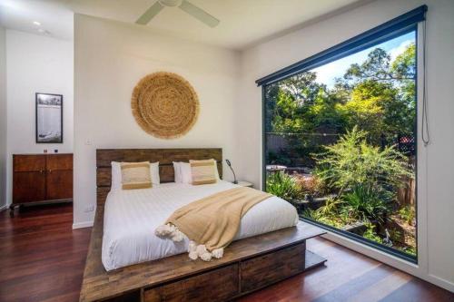 a bedroom with a bed and a large window at Modern 3-Bedroom Byron Bay Escape With Sauna in Byron Bay