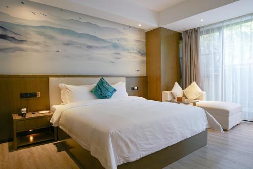 a bedroom with a large white bed and a window at Paco Hotel Tiyuxilu Metro Guangzhou-Close to subway entrance in Guangzhou