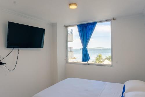 a bedroom with a window with a view of the ocean at Acogedor Apartaestudio Laguito 1 Habitacion N4A in Cartagena de Indias
