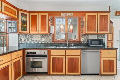 a kitchen with wooden cabinets and a sink at Spacious Lakefront Retreat w/Stunning Views in Hinesburg