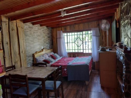 een slaapkamer met een bed en een tafel in een kamer bij Cabañas El Remanso in Linares