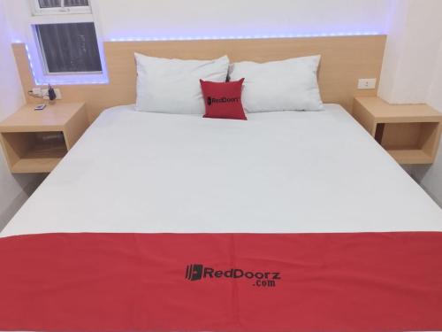 białe łóżko z czerwoną kanapą na górze w obiekcie RedDoorz Syariah @ Gedong Air Lampung w mieście Kedaton