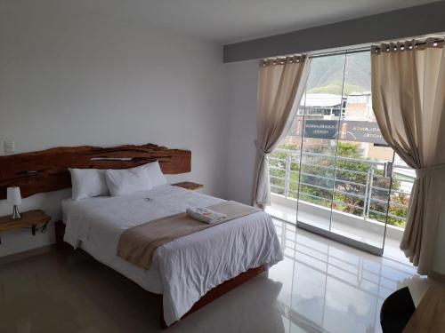 1 dormitorio con cama y ventana grande en CasaBlanca Hotel, en Huambo