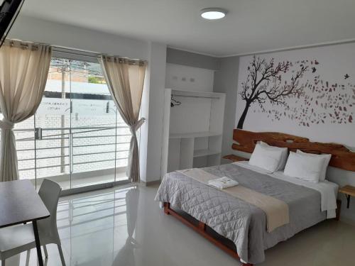 um quarto com uma cama com um mural de árvore na parede em CasaBlanca Hotel em Huambo