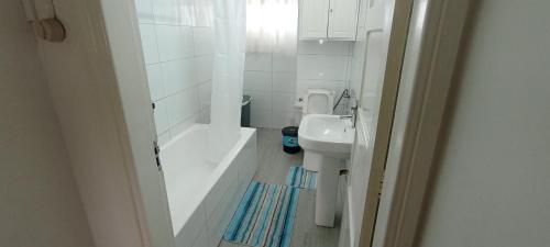 a bathroom with a tub and a sink and a toilet at Cozzy 24 in Maputo